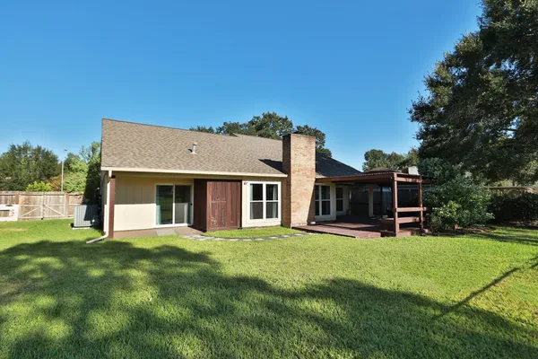 a view of a house with a big yard and large trees