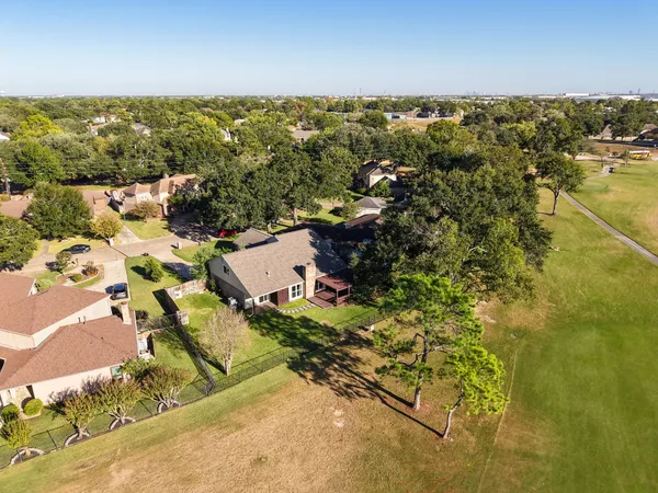an aerial view of residential houses with outdoor space and ocean view