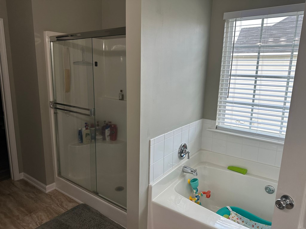26 Apache Trail Fort Mitchell, AL 36856 - Photo 11 of 18 a bathroom with a bathtub a window and a shower