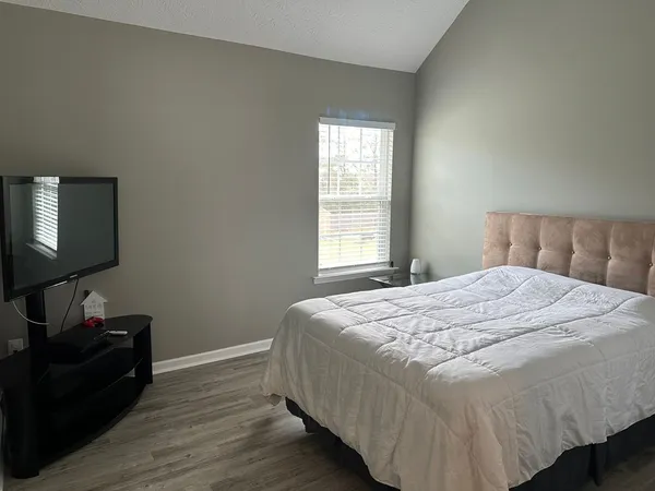 a bedroom with a bed and a flat screen tv