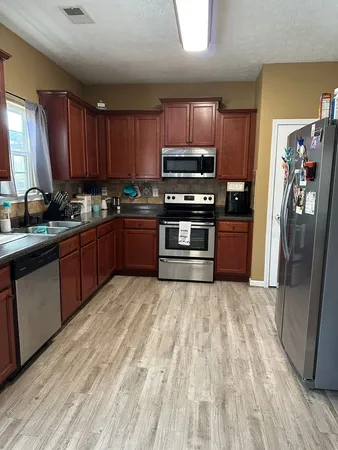 a kitchen with stainless steel appliances granite countertop a stove refrigerator sink and microwave