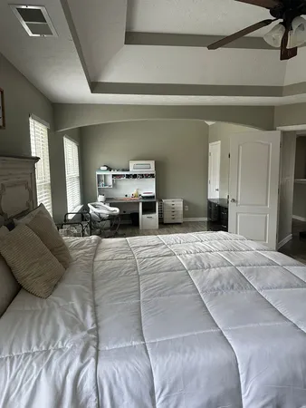 a bedroom with a large bed and a chandelier