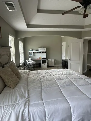 a bedroom with a large bed and a chandelier