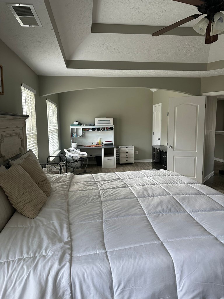 26 Apache Trail Fort Mitchell, AL 36856 - Photo 8 of 18 a bedroom with a large bed and a chandelier