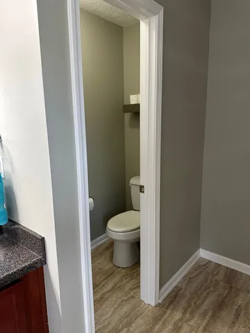 a bathroom with a granite countertop toilet and a sink