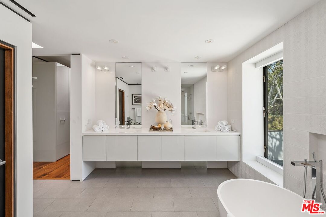 1005 Elden Way Beverly Hills, CA 90210 - Photo 40 of 62 a bathroom with a bathtub sink and mirror