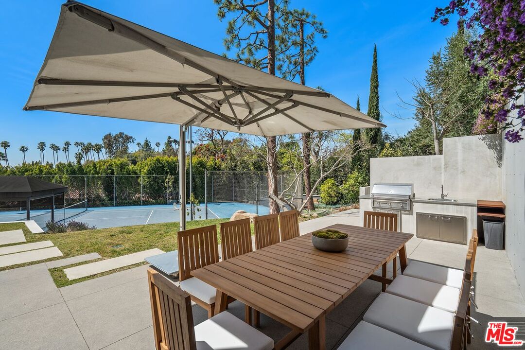 1005 Elden Way Beverly Hills, CA 90210 - Photo 53 of 62 a view of a patio with couches table and chairs under an umbrella