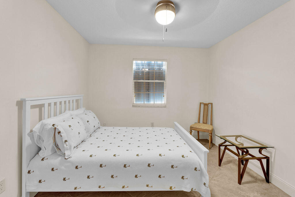 121 Waterside Drive Hypoluxo, FL 33462 - Photo 12 of 22 a bedroom with a bed and a table in it