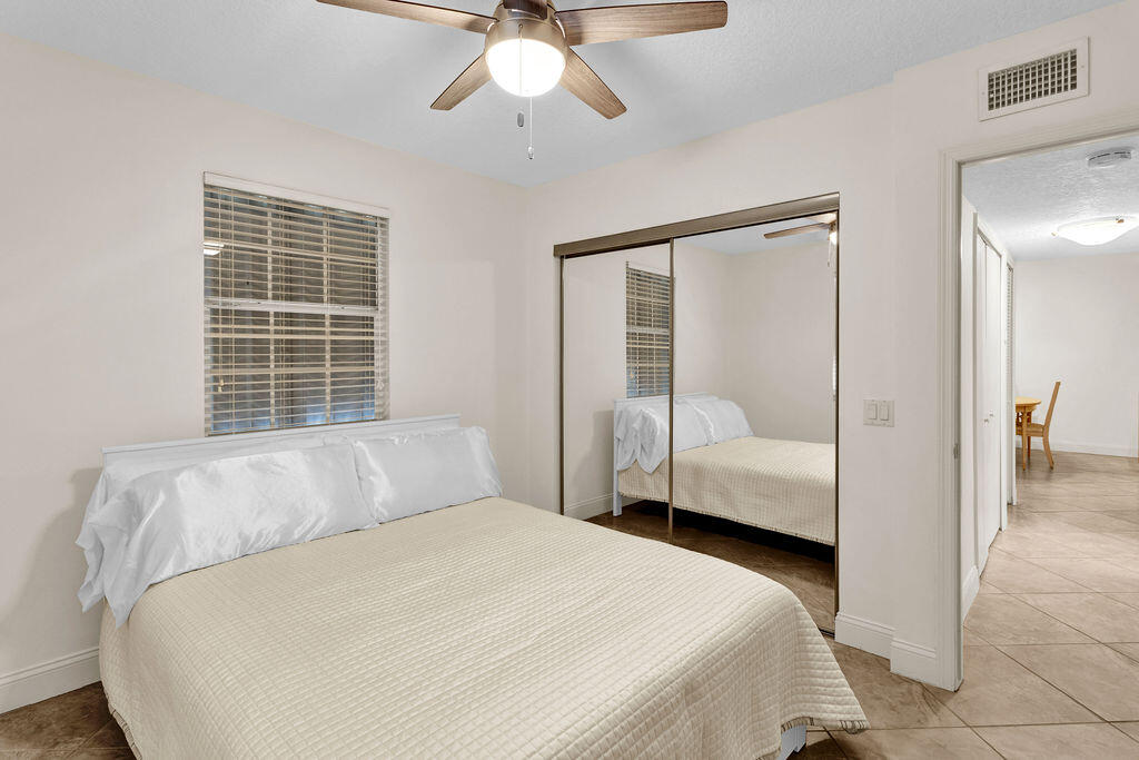 121 Waterside Drive Hypoluxo, FL 33462 - Photo 15 of 22 a bedroom with a large bed and a chandelier