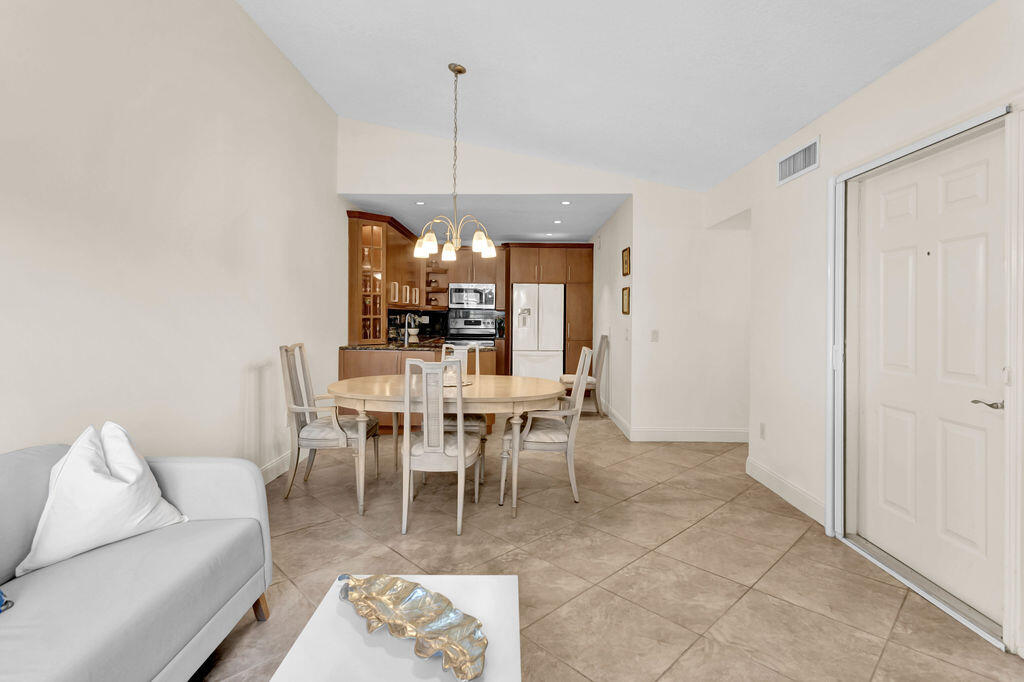 121 Waterside Drive Hypoluxo, FL 33462 - Photo 2 of 22 a dining room with furniture a chandelier and window