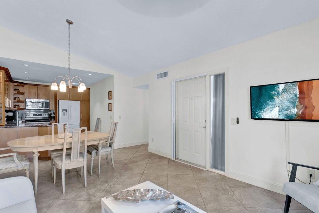 121 Waterside Drive Hypoluxo, FL 33462 - Photo 3 of 22 a dining room with furniture a rug and a chandelier