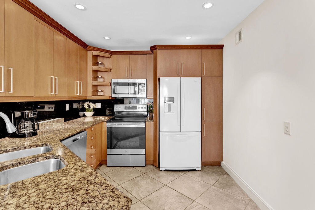 121 Waterside Drive Hypoluxo, FL 33462 - Photo 7 of 22 a kitchen with stainless steel appliances granite countertop a refrigerator and a stove top oven
