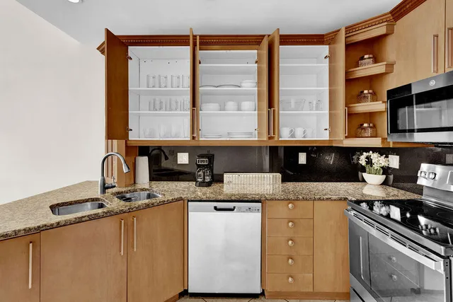 a kitchen with stainless steel appliances granite countertop a sink stove and cabinets