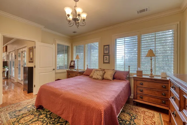 a spacious bedroom with a bed and a chandelier