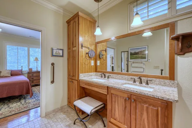 a en suite bathroom with a granite countertop sink a toilet a mirror and shower