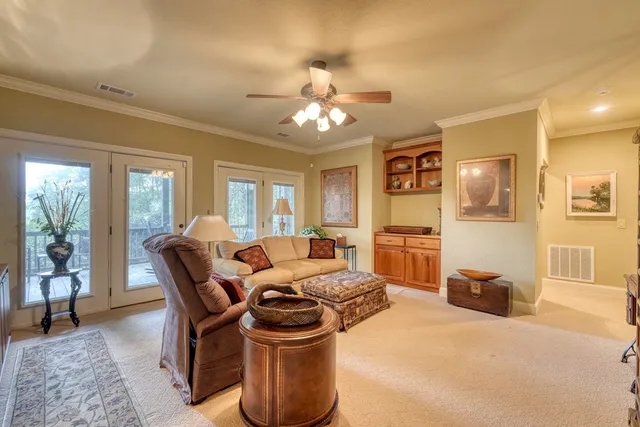 a living room with furniture a chandelier and a dining table