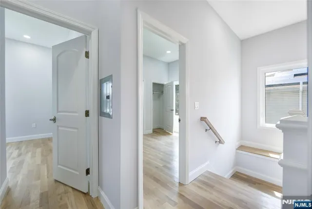 a view of a hallway with wooden floor and staircase