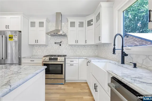 a kitchen with granite countertop white cabinets and appliances