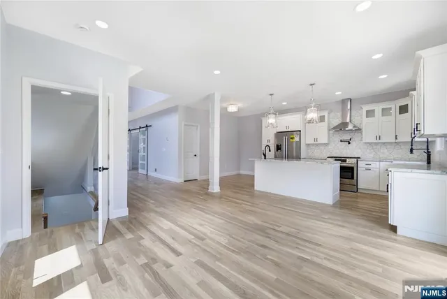a open kitchen with white cabinets and stainless steel appliances