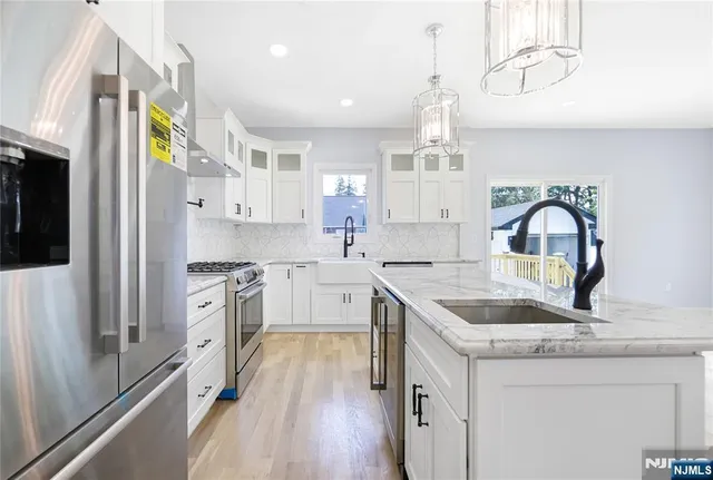 a kitchen with granite countertop a sink stainless steel appliances and cabinets