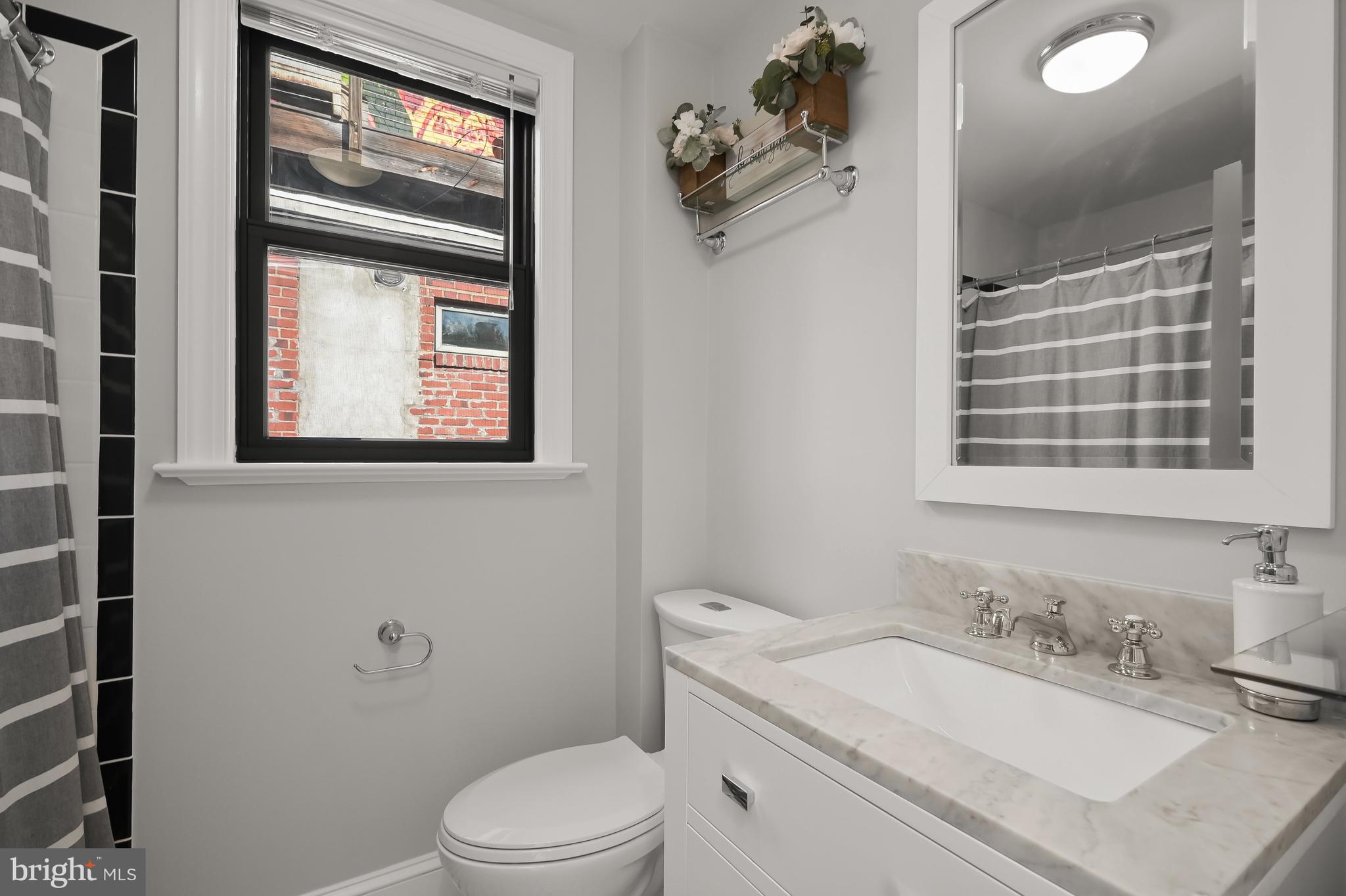 1733 11th Street Northwest Washington, DC 20001 - Photo 15 of 21 a bathroom with a granite countertop toilet a sink and mirror