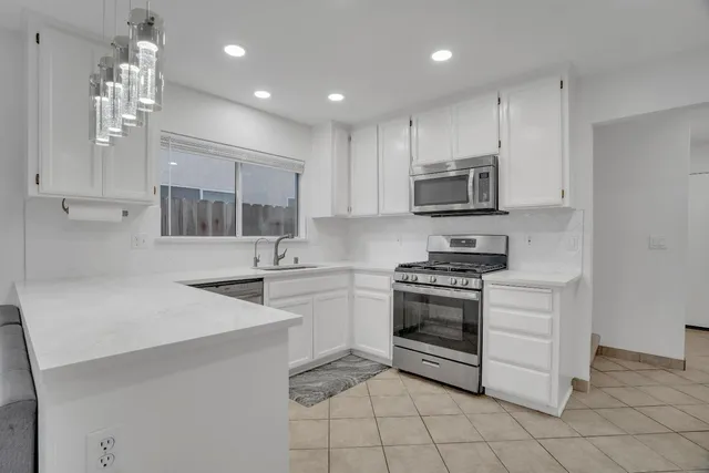 a kitchen with stainless steel appliances granite countertop a stove and a sink