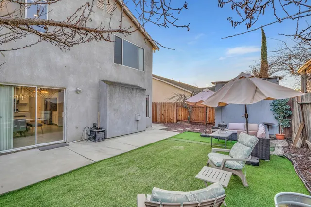 a view of a chair and table in backyard of the house