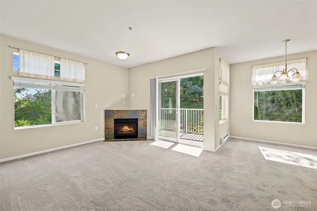 a view of an empty room with a fireplace and a window