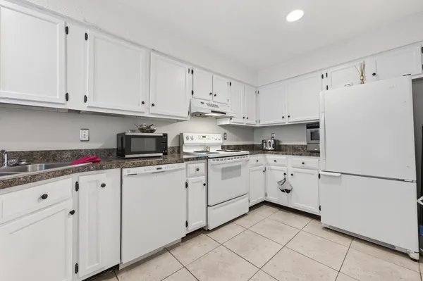 a view of an empty room with a window and a kitchen