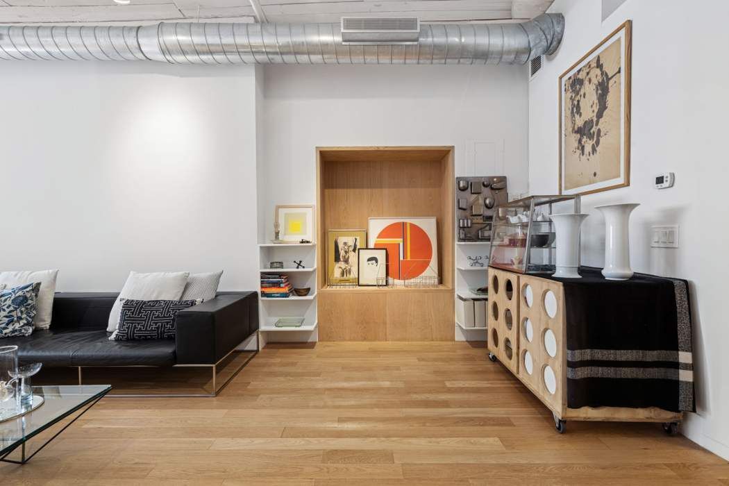 97 Crosby Street, Unit 1 Manhattan, NY 10012 - Photo 4 of 15 a living room with furniture and a flat screen tv