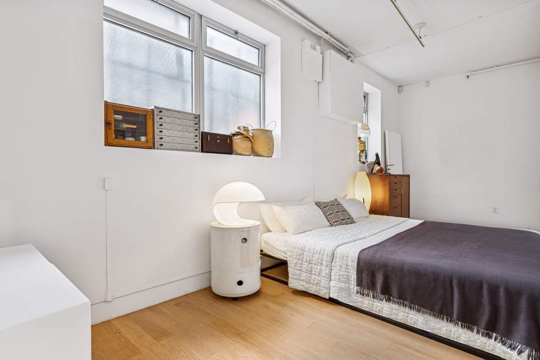 97 Crosby Street, Unit 1 Manhattan, NY 10012 - Photo 8 of 15 a bedroom with a bed and a cabinets