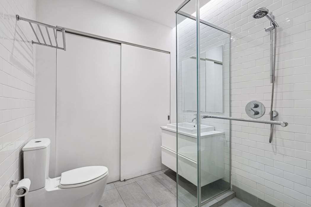 97 Crosby Street, Unit 1 Manhattan, NY 10012 - Photo 9 of 15 a bathroom with a shower and a toilet