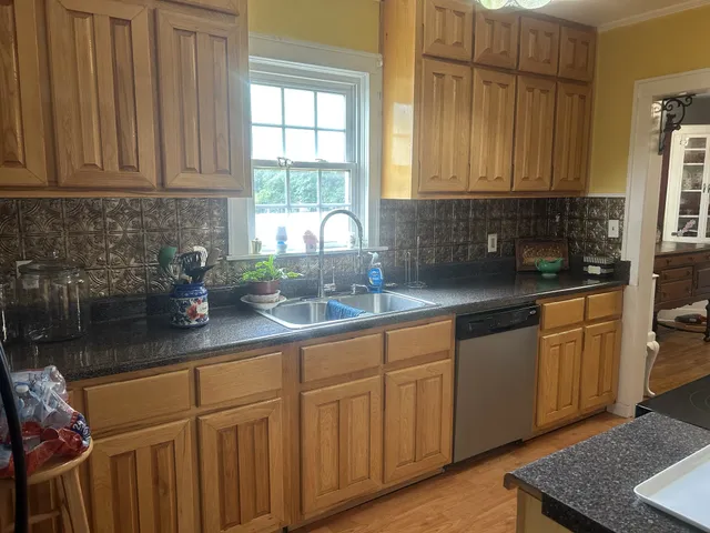 a kitchen with stainless steel appliances granite countertop a sink a stove cabinets and a counter top space