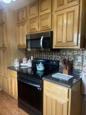 a kitchen with stainless steel appliances granite countertop a stove a sink and a microwave