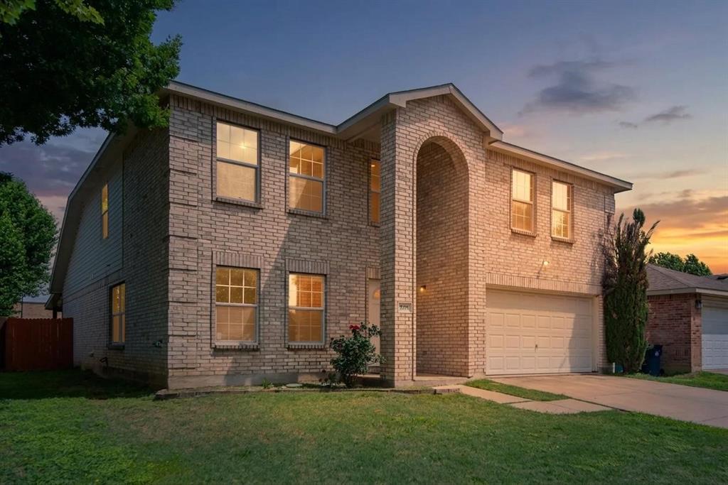 5718 Green Ivy Road Denton, TX 76210 - Photo 2 of 37 Two-story brick exterior featuring an arched entryway, attached garage with a white door, and multiple windows with white trim