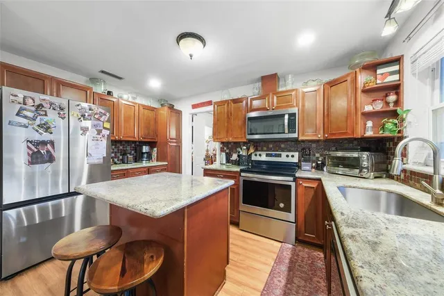 a kitchen with stainless steel appliances granite countertop a stove refrigerator sink and cabinets
