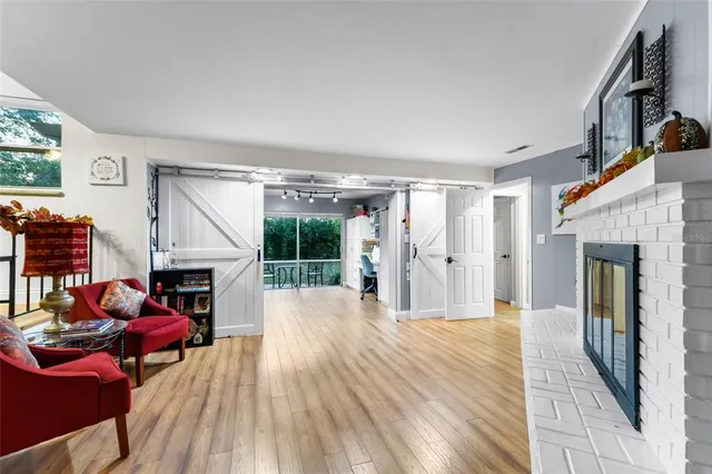 a living room with furniture a fireplace and a floor to ceiling window