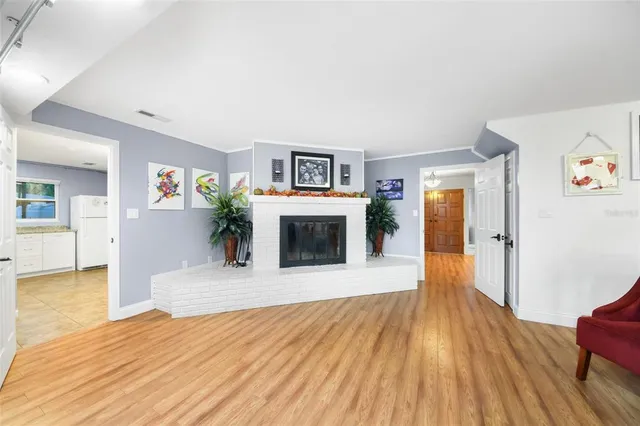 a view of a livingroom with wooden floor and a fireplace