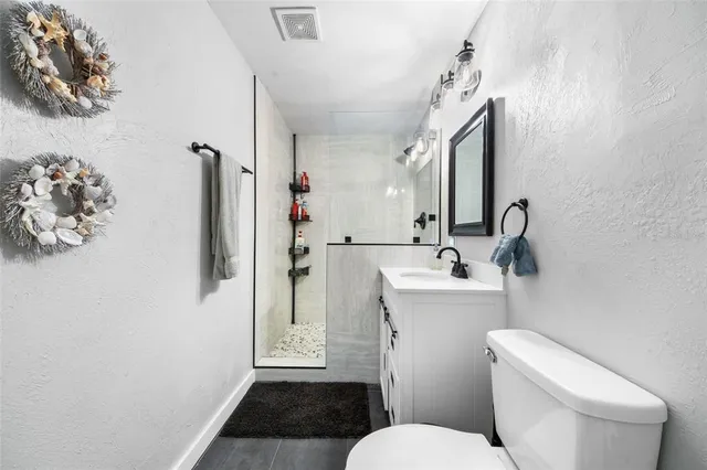 a bathroom with a sink a toilet and shower