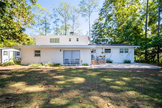 a view of a house with a yard and large tree