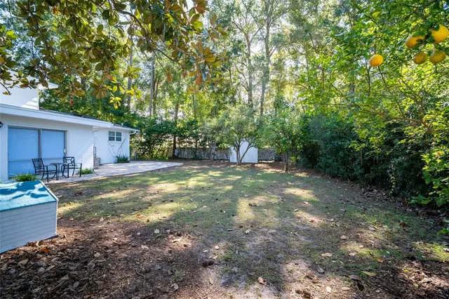 a view of a white house next to a yard
