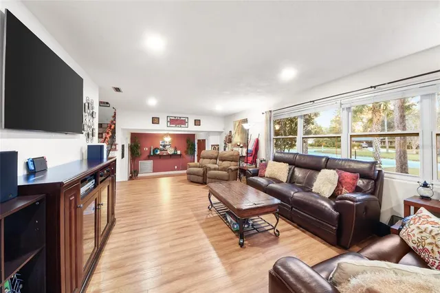 a living room with furniture a flat screen tv and a large window