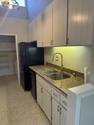 a kitchen with stainless steel appliances granite countertop a sink and a refrigerator