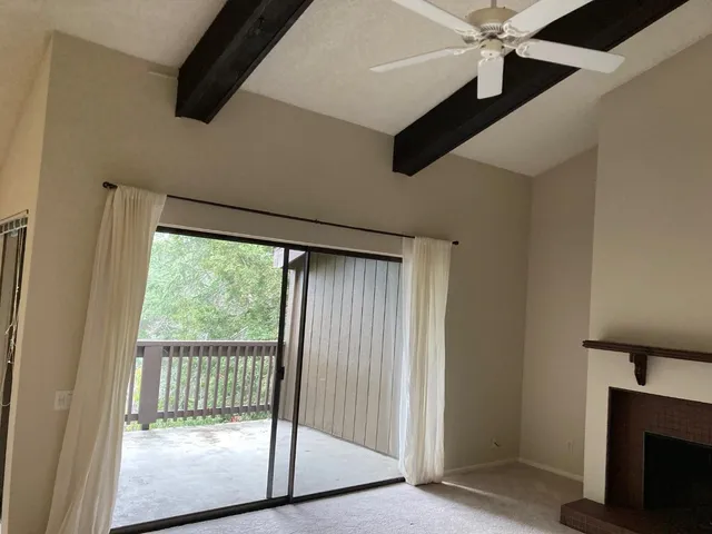 a view of a livingroom with wooden floor a ceiling fan and window