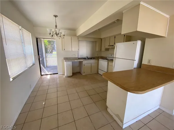 a kitchen with stainless steel appliances granite countertop a refrigerator a sink a stove and white cabinets