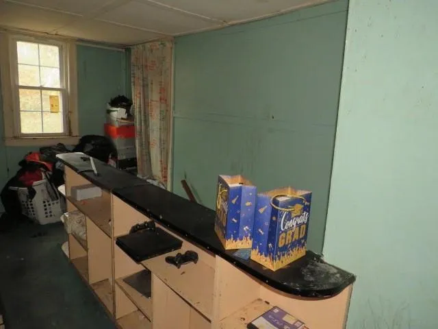 a bedroom with a bed and a dresser with the shoe rack