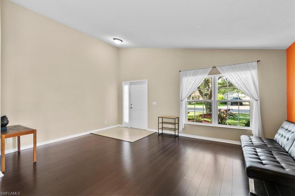 2806 Orange Grove Trail Naples, FL 34120 - Photo 2 of 24 an empty room with wooden floor and windows