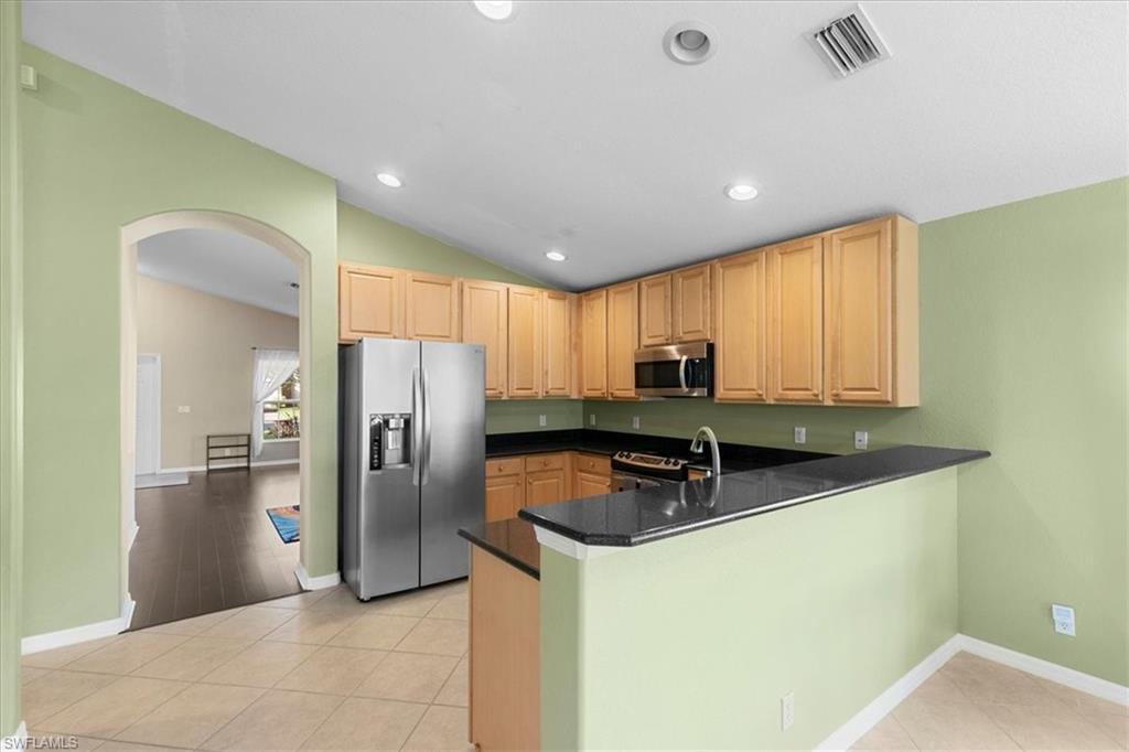 2806 Orange Grove Trail Naples, FL 34120 - Photo 5 of 24 a kitchen with stainless steel appliances granite countertop a sink a stove and refrigerator