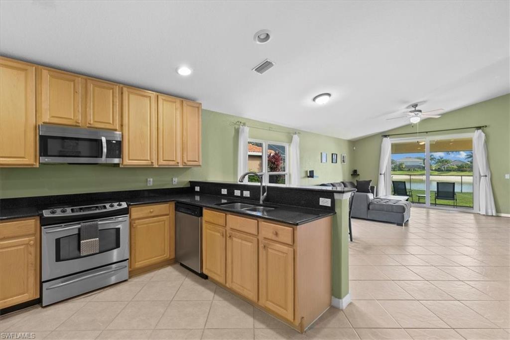 2806 Orange Grove Trail Naples, FL 34120 - Photo 6 of 24 a kitchen with stainless steel appliances granite countertop a stove a sink and a microwave