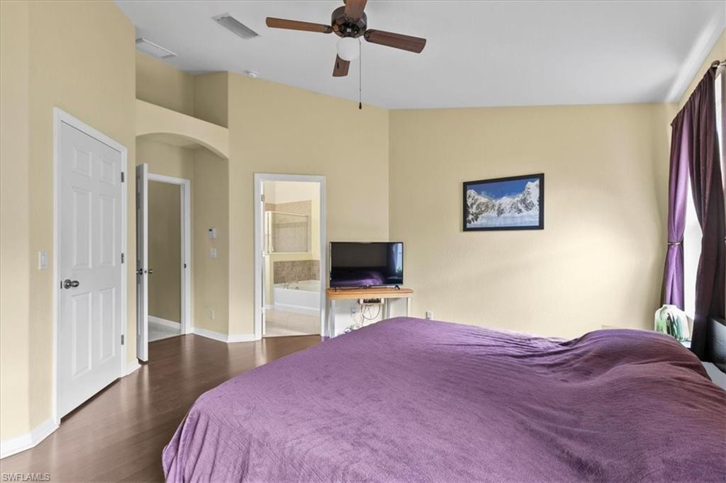 2806 Orange Grove Trail Naples, FL 34120 - Photo 9 of 24 a bedroom with a bed and a flat screen tv